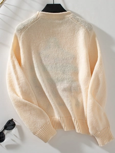 Back view of cream knit sweater showing thick texture and ribbed hem for autumn winter