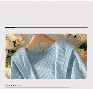 Detail view of light blue knitted cardigan featuring ribbed texture and V-neckline