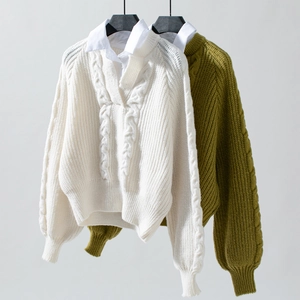 Detailansicht der Zopfstrickpullover mit Hemdkragen-Lagenlook und dicker Textur
