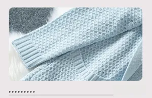 Detail of waffle knit texture and ribbed cuff on a loose blue cardigan sweater for women