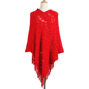 Red knit poncho for women featuring hollow crochet patterns and long fringe tassels