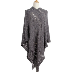 Dark grey crochet knit poncho featuring intricate hollow patterns and long tassel fringe