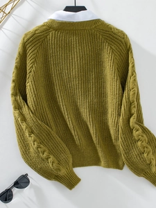 Detail von grünem Strickpullover mit weißem Hemdkragen in Lagen-Optik