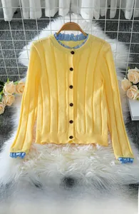 Detailed view of yellow ribbed knit cardigan with blue plaid trim and buttons