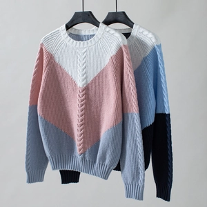 Detailed macro view of heavy cable knit texture and contrasting V-shape color block pattern