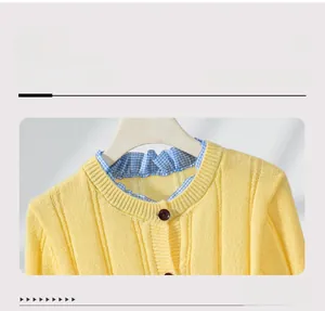 Detail of yellow knit cardigan featuring a ruffled plaid collar and brown buttons
