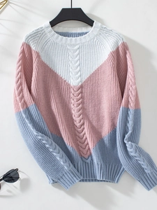 Close-up of tricolor cable knit sweater featuring white pink and blue patchwork design