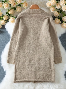 Detail of warm apricot chunky knit texture and thick ribbed cuffs on a long cardigan