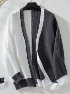Detail of color block knit cardigan featuring ribbed texture and grey-white contrast
