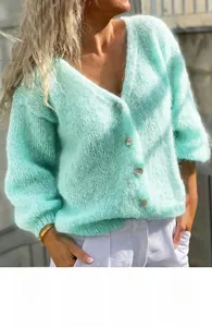 Close-up of mint green V-neck knit cardigan with textured mohair and shell buttons