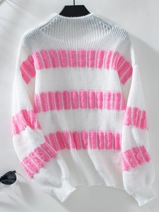 Detail shot of pink striped knitted sweater showing soft fabric texture and ribbed cuffs