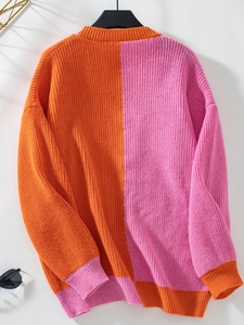 Detail of color-block knit sweater featuring ribbed texture in vibrant orange and pink