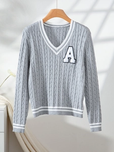 Detail of grey V-neck cable knit sweater with white stripes and A letter embroidery
