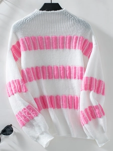 Detail of pink and white striped knit texture on a loose long-sleeved women sweater