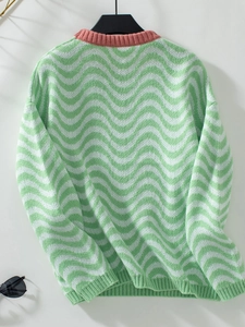 Close-up of chevron wave stripes and pink contrast crew neck on knit sweater