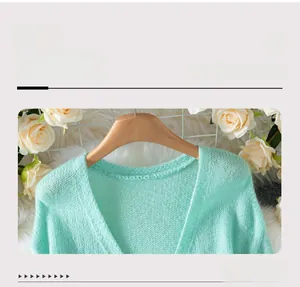 Detail view of the deep V-neckline and mint green knit texture on a cozy cardigan