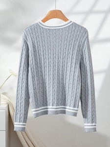 Rear view of a grey cable-knit sweater with white stripes on hem and cuffs hanging on a rack