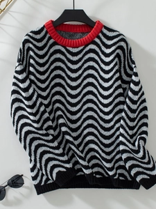 Detail of chevron wave knit texture and contrasting red ribbed neckline on the sweater