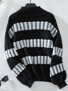 Close-up of black and white striped knit sweater with thick texture and drop shoulder