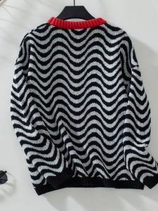 Detailed view of chevron wave pattern knit with a contrasting red ribbed crew neckline