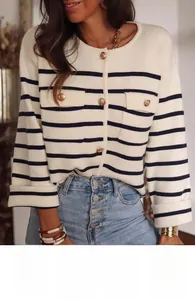 Close-up of golden buttons and textured knit details on a striped cardigan