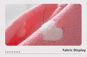 Détail macro du tissu rose doux du gilet avec broderie de cœur blanc texturé