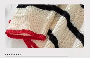 Dettaglio maglione in maglia con polsino a coste rosso e trama a righe a contrasto