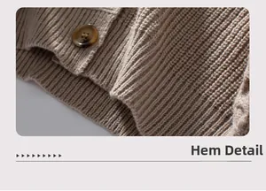 Detail view of oat-colored knitted cardigan featuring ribbed hem and amber tortoiseshell button
