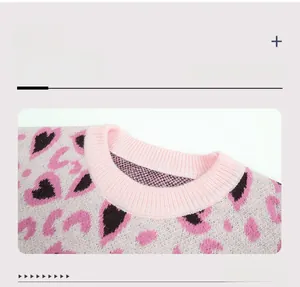 Close-up of pink leopard heart pattern knit sweater with ribbed round crew neckline