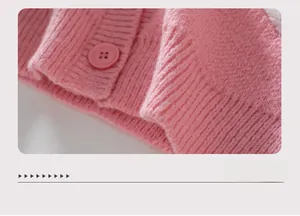 Vue détaillée de l'ourlet du cardigan en tricot rose avec texture côtelée et bouton assorti