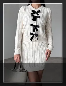 Détail de la maille torsadée et nœuds en satin noir sur l'ensemble blanc tricoté