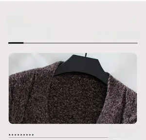 Close-up of neckline detail on brown cable knit cardigan featuring textured wool blend fabric