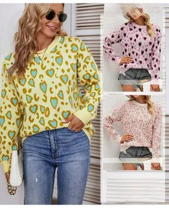 Detail of crew neck and ribbed cuffs on heart and leopard print knit sweater