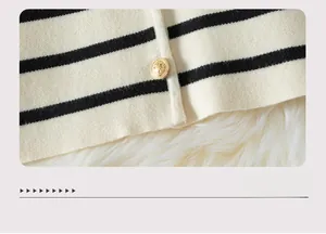 Close-up of black and white striped knit cardigan hem with a gold embossed button