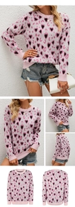 Detail of pink knitted sweater featuring black heart and leopard prints with ribbed cuffs