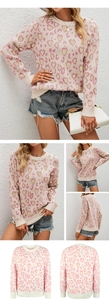 Detail of pink knit sweater showing color-block heart patterns and ribbed crewneck collar