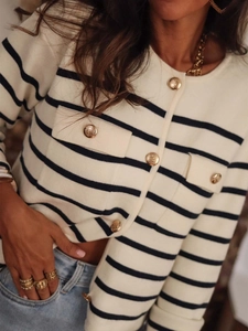 Close-up of striped knit cardigan with vintage gold buttons and front pockets