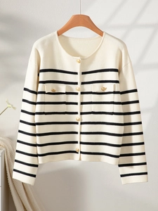 Close-up of black and white striped cardigan with gold buttons and flap pocket details