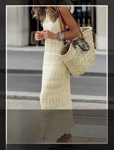 Detail of elegant beige sleeveless hollow knit dress with floral crochet pattern