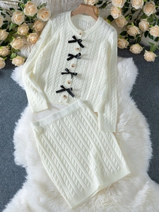 Détails du cardigan en maille torsadée beige avec nœuds noirs et boutons en bois
