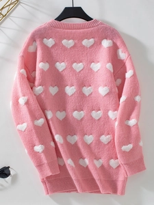Détail du cardigan rose en tricot avec broderie cœur et poignets côtelés