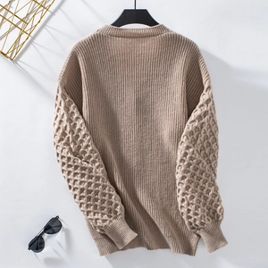 Close-up of khaki knitted cardigan showing textured bubble sleeves and ribbed cuffs details