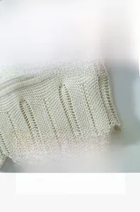 Detailed macro view of cream hollow knit fabric texture with scallop edge design