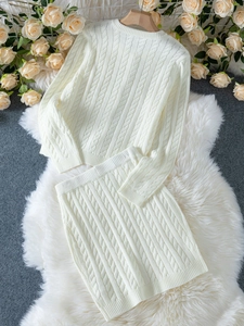 Détail d'un ensemble en maille torsadée crème avec pull et jupe sur fausse fourrure