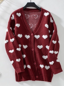 Détail du gilet bordeaux avec broderie cœur blanche et texture en tricot avec boutons