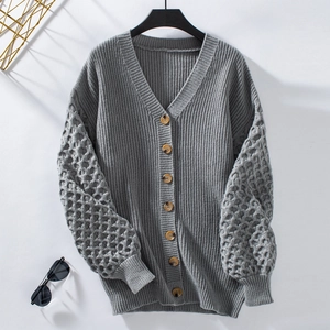 Detail of grey V-neck knit cardigan with tortoise buttons and hollow mesh sleeves