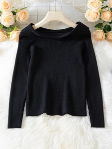 Detail of black ribbed knit sweater with elegant off-shoulder neckline on hanger