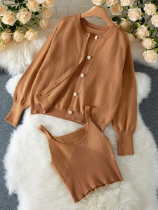 Detail of warm caramel knit cardigan and vest set with white buttons on soft plush rug
