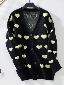 Détail du cardigan en maille montrant la broderie cœur bouclée et boutons noirs