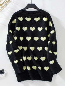 Détail du pull en maille noir avec broderie de cœurs jaunes et poignets côtelés